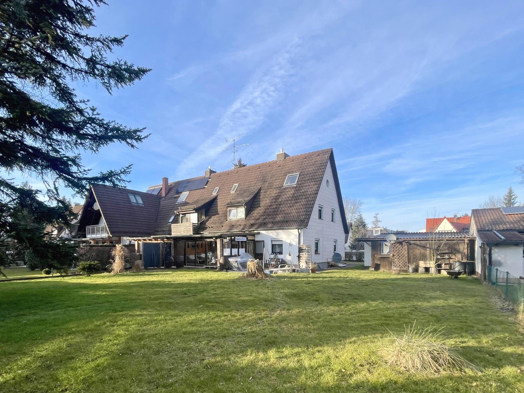 Großes Einfamilienhaus mit Satteldach und großzügigem Garten, inklusive Nebengebäuden und Rasenfläche