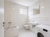 Charmantes Eckhaus mit drei Wohneinheiten und sonnigem Grundstück - Visualisiert leerstehend: Badezimmer mit Badewanne und hellem Fliesendesign
