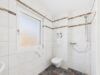 Charmantes Eckhaus mit drei Wohneinheiten und sonnigem Grundstück - Modernes Badezimmer mit Dusche, Fenster und zeitlosen Design