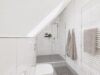 Charmantes Eckhaus mit drei Wohneinheiten und sonnigem Grundstück - Modernes Badezimmer im Dachgeschoss mit Dusche und stilvoller Fliesengestaltung